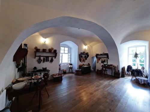 a large living room with an archway and wooden floors at Penzion hradu Svojanov in Svojanov