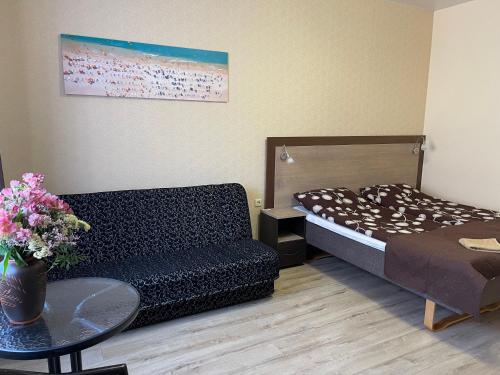 a living room with a couch and a bed at Apartamentų nuoma Baltijos perlas in Šventoji