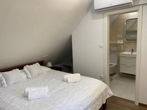a bedroom with a white bed with two towels on it at Kuća za odmor "Villa Oliva" in Ivan Dolac