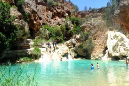 a group of people in the water in a river at Cabaña de madera especial y acogedora in Cardenete