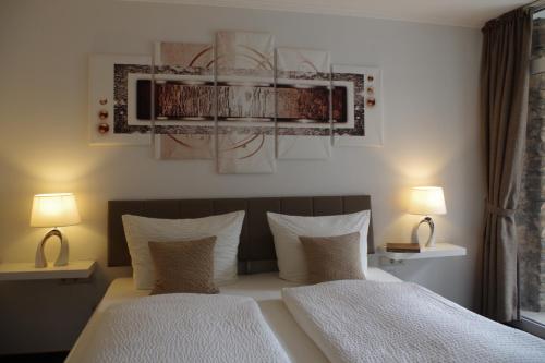 a bedroom with two beds and two lamps on tables at Gast und Weinhof Beim Schneemann in Valwig