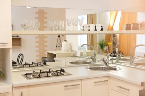 a kitchen with two sinks and a mirror at Apartment VIP in Tiraspol