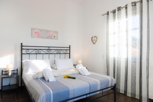 um quarto com uma cama com um cobertor azul e branco em Petala House em Cherronisos