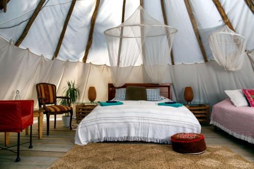 a bedroom with a bed in a yurt at Goodmuda Tipi's in Grândola