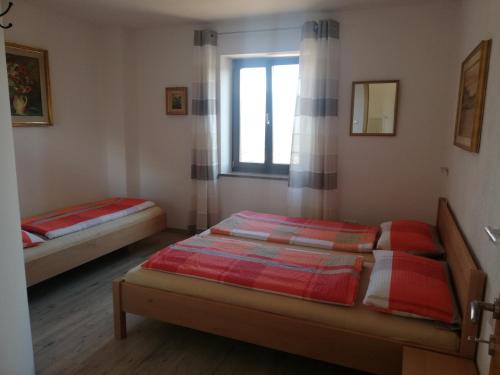 Duas camas num quarto com uma janela em Haus Möltner - Apartment Aviam em Caldaro