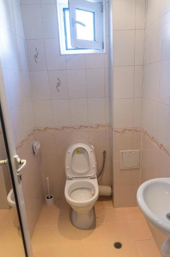 a small bathroom with a toilet and a window at Къща за гости Мони in Sandanski