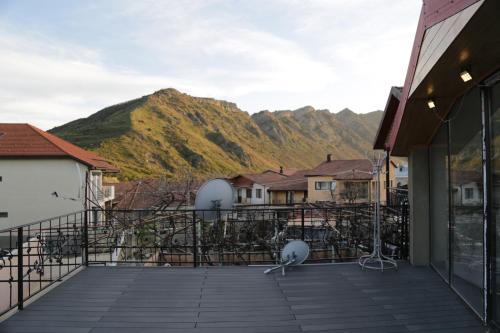 a bird on a balcony with mountains in the background at Hotel 12 Tve in Mtskheta