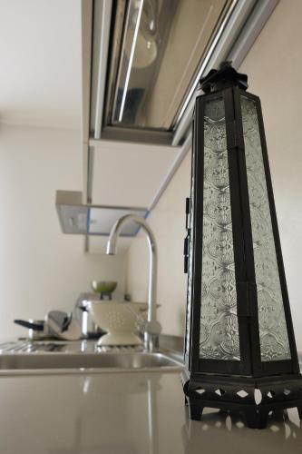a lantern sitting on a kitchen counter next to a sink at Appartamenti Alle 5 Torri in Mezzolombardo