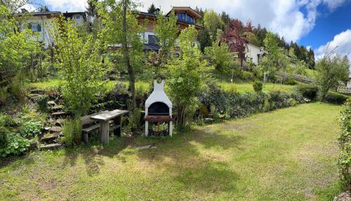 a garden with a bench and a grill in the grass at Basislager Fieberbrunn in Fieberbrunn