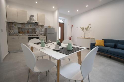 a kitchen and living room with a white table and chairs at Casanica-Taormina in Taormina