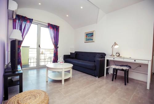 a living room with a blue couch and a table at LURIA apartmani - Self Check-in in Čakovec