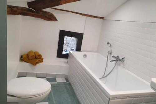 une salle de bain avec une baignoire blanche et des toilettes dans l'établissement Appartement de charme dans maison fin XIXème, à Santo-Pietro-di-Tenda