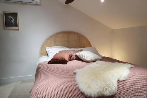 - un lit avec des oreillers en fourrure dans l'établissement Appartement de charme dans maison fin XIXème, à Santo-Pietro-di-Tenda