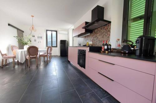 une cuisine avec un comptoir et une table avec des chaises dans l'établissement Appartement de charme dans maison fin XIXème, à Santo-Pietro-di-Tenda