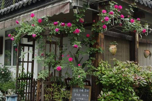 a house with pink flowers on it at Hangzhou JiuYueJi Bed&Breakfast in Hangzhou