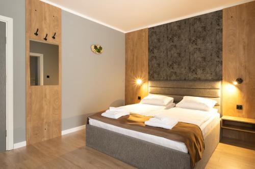 a bedroom with a large bed with wooden walls at Villa Pino in Velingrad