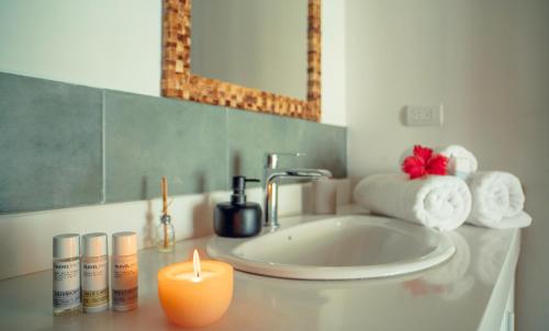 a bathroom with a sink and a candle on a counter at Vikara in Olón