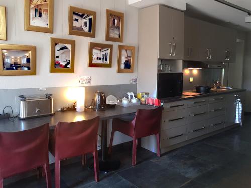 a kitchen with a table and chairs and a counter at BnB Comfort Guesthouse Olten - Lostorf in Lostorf