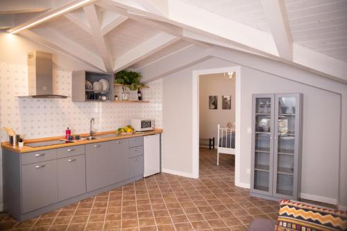 a kitchen with gray cabinets and a tile floor at Da Palù in Castellabate