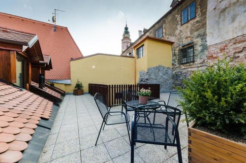 a patio with two chairs and a table and a building at Pension Faber in Český Krumlov
