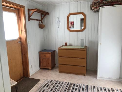 a room with a wooden dresser and a mirror at Tildas Urshult in Urshult
