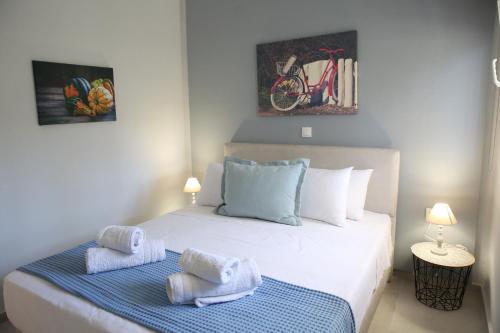 una camera da letto con un letto e asciugamani di ENCANTO PEFKOHORI a Pefkohori