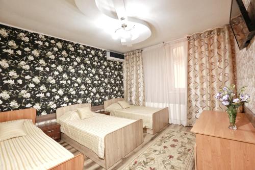 Habitación con 2 camas y papel pintado con motivos florales en Villa de Nord, en Soroca