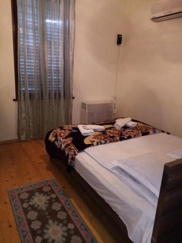 a bedroom with a bed and a window at Maya Guest House in Sighnaghi