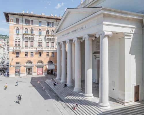 um edifício com colunas brancas em frente a um edifício em ViandanteHome, Luxury Rooms em Trieste
