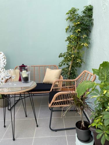 uma varanda com um banco, uma mesa e plantas em Melenia Suites in Ilha de Rhodes