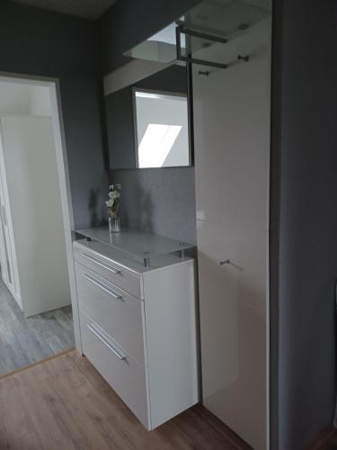 a kitchen with a white cabinet and a mirror at Haus Angelika in Berumbur