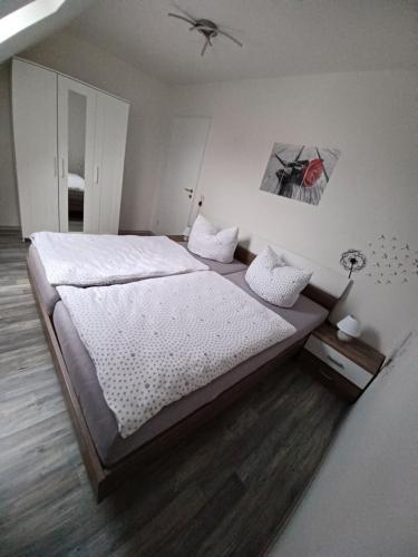 a bedroom with a large bed with white sheets at Haus Angelika in Berumbur