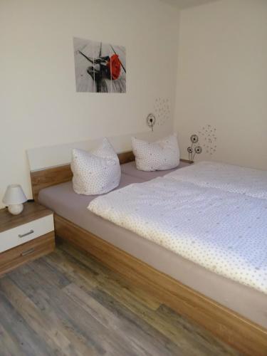 a bedroom with a bed with white sheets and pillows at Haus Angelika in Berumbur
