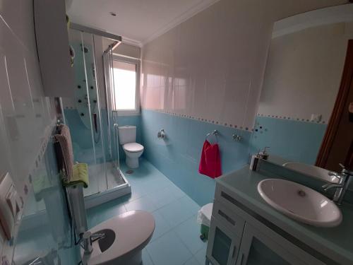 een badkamer met een wastafel, een toilet en een douche bij APARTAMENTO BAHÍA DE SANTANDER in Santander