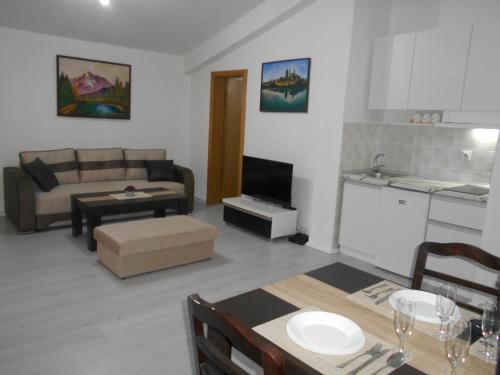 un soggiorno con divano e tavolo e una cucina di BFS Apartment a Ohrid