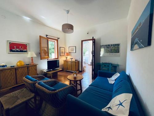 sala de estar con sofá azul y sillas en La maison sul mare, en San Vito lo Capo