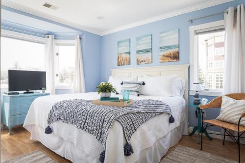 1 dormitorio azul con 1 cama y TV en New Listing Beach Bliss 211! Stunning bay view en Traverse City