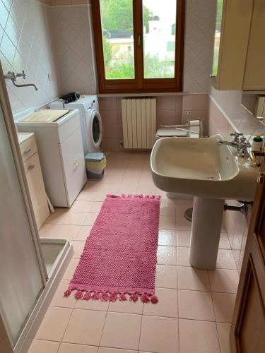 a bathroom with a sink and a washing machine at Casa di Mary in Grottammare