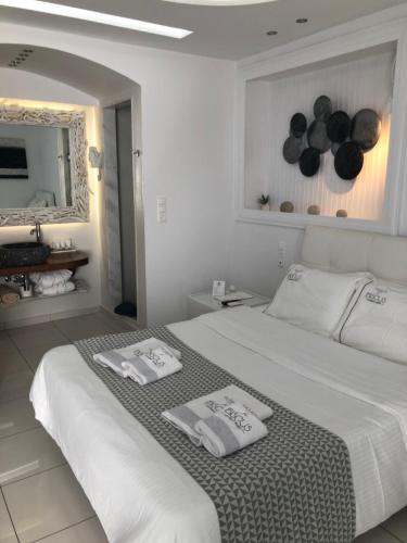 a white bedroom with two towels on a bed at Ibiscus Boutique in Mýkonos City