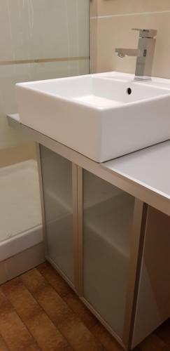 La salle de bains est pourvue d'un lavabo blanc et d'une baignoire. dans l'établissement Studio Naturiste 