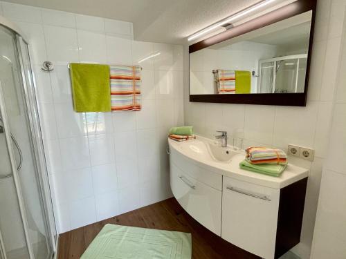ein Bad mit einem Waschbecken und einem Spiegel in der Unterkunft Ferienhaus Rutar in Sankt Kanzian am Klopeiner See