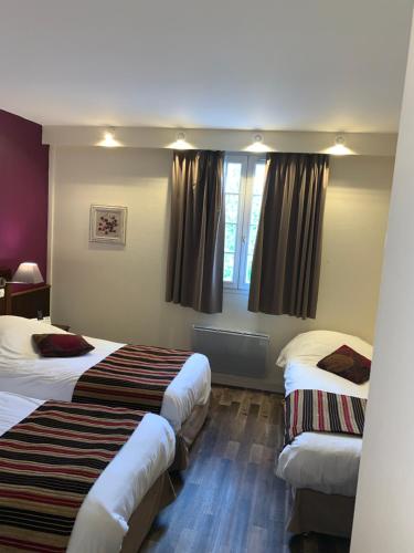 a hotel room with two beds and a window at Logis Hôtel Les Nymphéas in Chaufour-lès-Bonnières