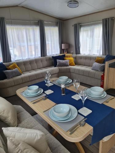 a living room with a table and a couch at The Tiddler - Plot 101, Woodlands Lodge Retreat, New Quay, West Wales in Llanina