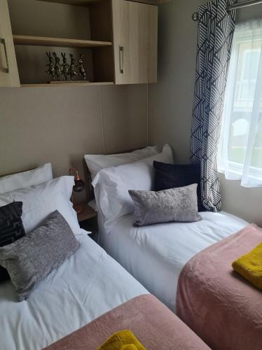 a room with two beds and a window at The Tiddler - Plot 101, Woodlands Lodge Retreat, New Quay, West Wales in Llanina