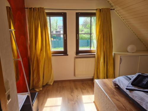 Habitación con cortinas amarillas, cama y ventana en Yellow House en Osnabrück