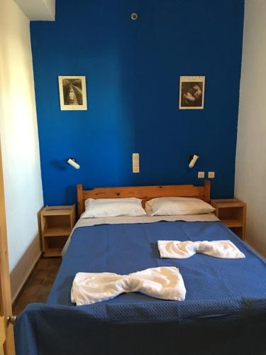 niebieska sypialnia z łóżkiem z dwoma ręcznikami w obiekcie Ilios w mieście Kalamaki
