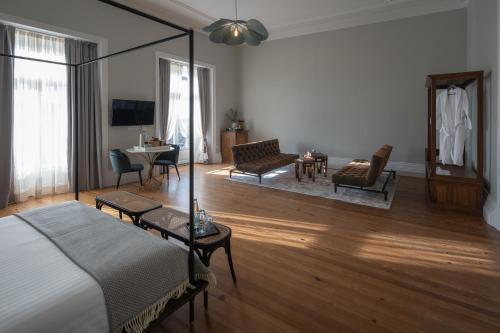 a bedroom with a bed and a living room at Casa do Pateo - Charming House Azores in Ponta Delgada