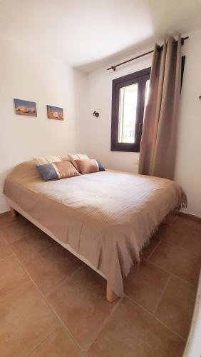 un grand lit dans une chambre avec une fenêtre dans l'établissement Porticcio - Casa Corsa, à Porticcio