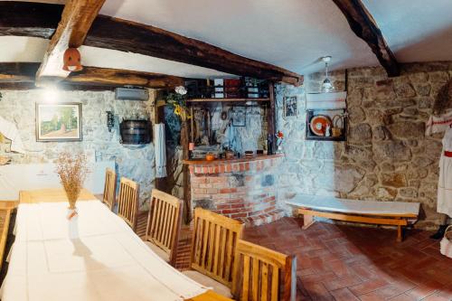 a room with a table and chairs and a stone wall at Kmečka hiša Bahor in Črnomelj