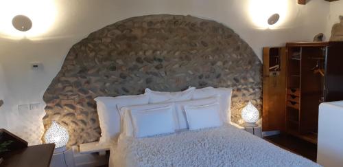 a bedroom with a large bed with a stone wall at La Torre Medioevale in Marne di Filago
